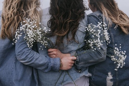 Women with arms around each other supportively