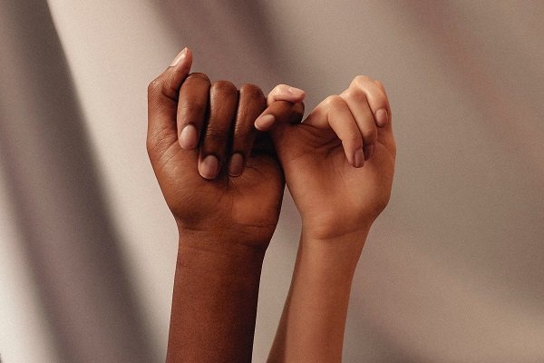 Pinky promise light and darker skin hands
