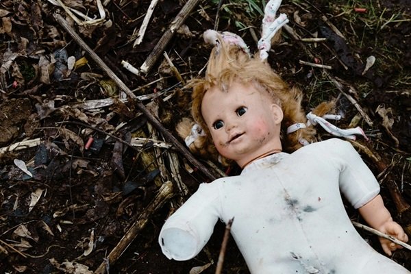 Dirty damaged doll on the ground - Tam's transition from Victim to Survivor